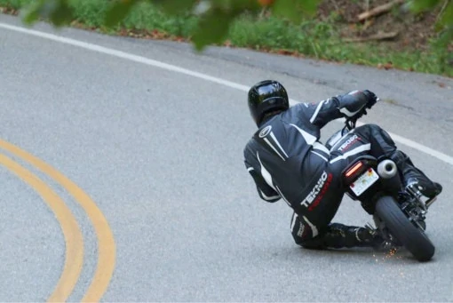 A motorcycle rider taking a corner with their left knee to the ground. 