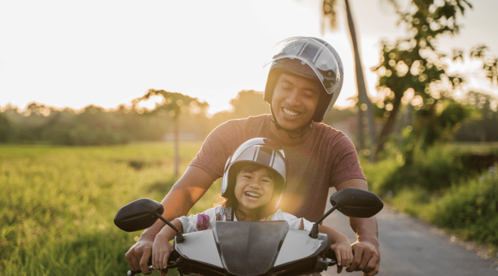 child with an adult riding on a motorcycle